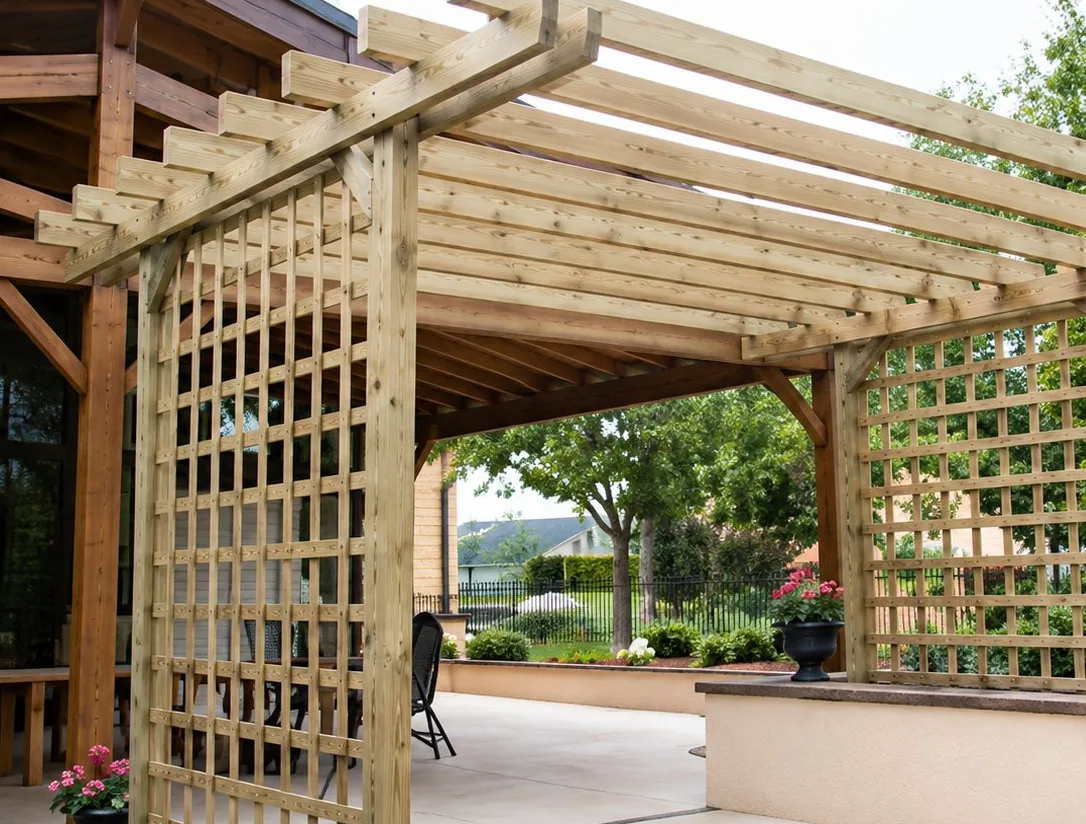 Une pergola en bois à lattes et panneaux de treillis couvre une terrasse donnant sur un jardin verdoyant.